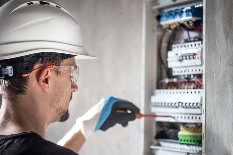 man-an-electrical-technician-working-in-switchboard-with-fuses-installation-and-connection-of-electrical-equipment-min (1)