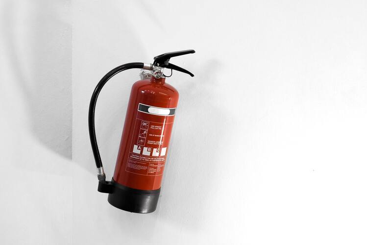 red-fire-extinguisher-on-white-wall-min (1) (1)
