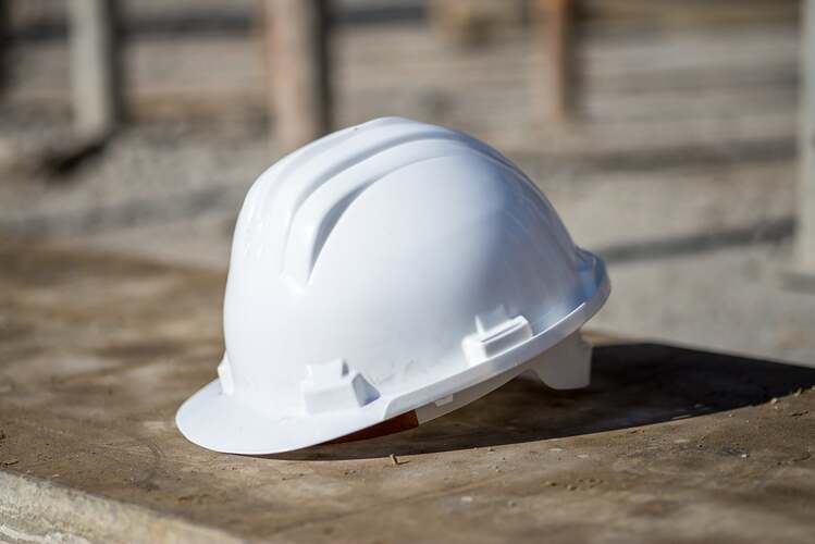 white-construction-helmet-on-the-ground-under-the-sunlight-min
